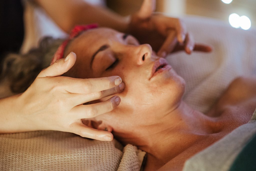 Woman receives facial massage from a professional at a spa
